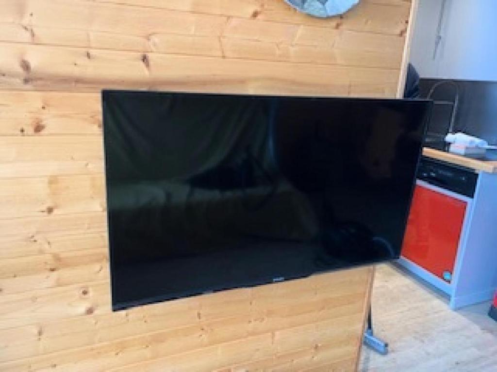 a large flat screen tv sitting on top of a wooden wall at Résidence Les Temples du Soleil - maeva Home - 2 Pièces 5 Personnes Sélect 52 in Val Thorens