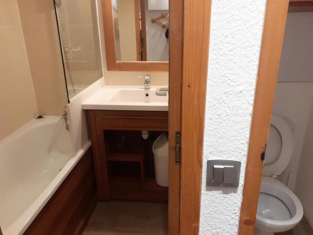 a bathroom with a sink and a toilet and a mirror at Résidence Les Temples du Soleil - maeva Home - 2 Pièces 5 Personnes Sélect 52 in Val Thorens