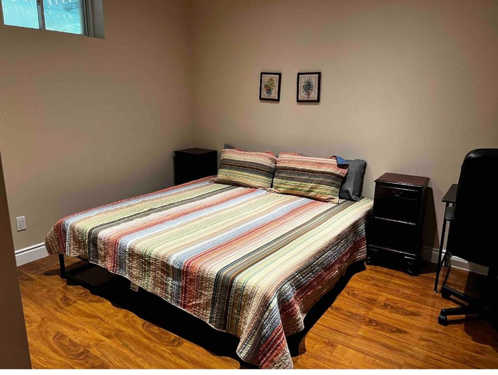 a bedroom with a bed with a striped comforter at 2 basement basement with parking in Richmond Hill