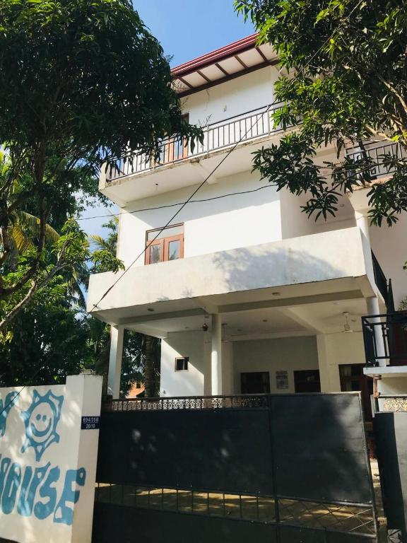 a white house with a fence in front of it at Sun Shine House in Matara
