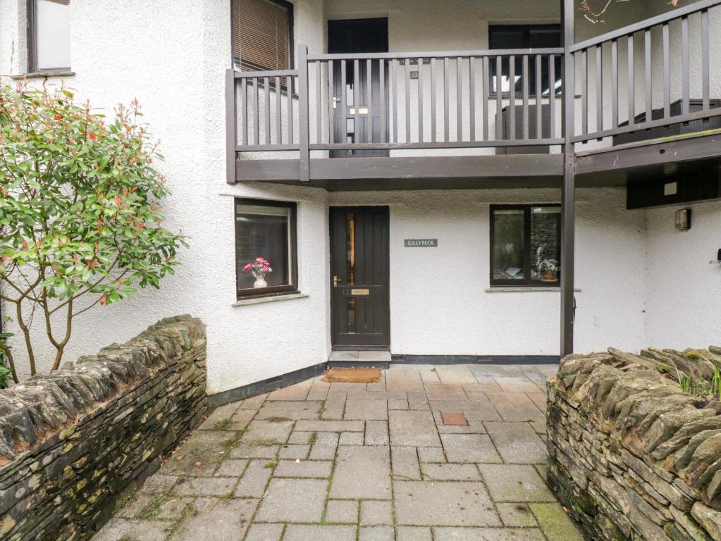 a white house with a balcony and a door at Gillybeck in Ambleside