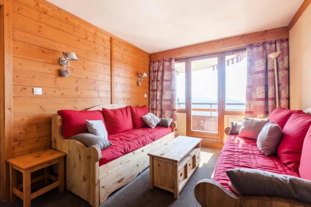 - un salon avec un canapé rouge et une fenêtre dans l'établissement Résidence L'Ours Blanc - maeva Home - 3 Pièces 8 Personnes Prestige MAE-1612, à Huez