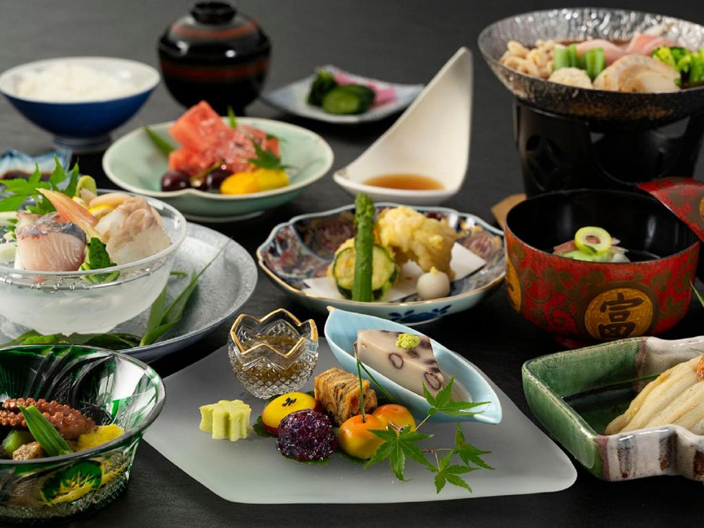 una mesa con muchos platos de comida. en Maple Arima en Kobe
