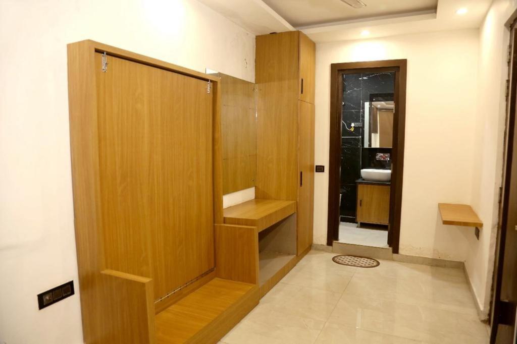 a bathroom with a wooden door and a sink at Bunk Hostel Delhi Best Backpacking Accommodation in New Delhi