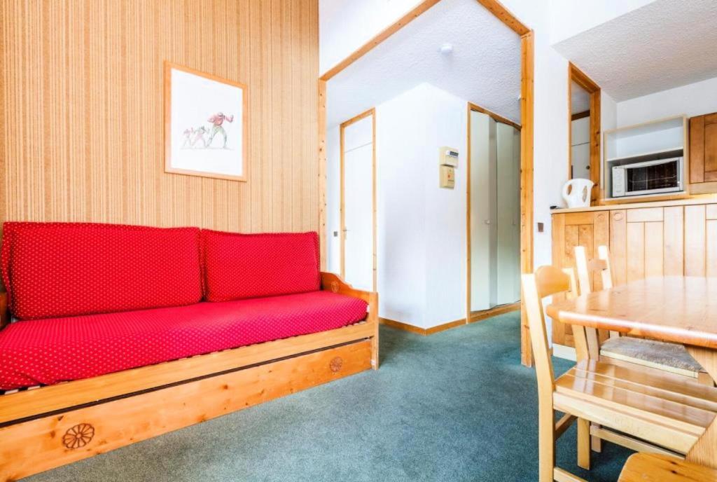 - un canapé rouge dans une chambre avec une table dans l'établissement Quartier Crève Cœur - maeva Home - Studio 4 Personnes Confort MAE-4102, à Valmorel