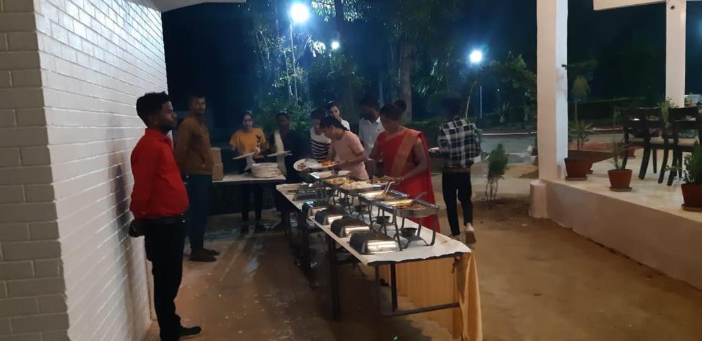 a group of people standing around a table with food at The Baagh Jungle Resort in Khajurāho