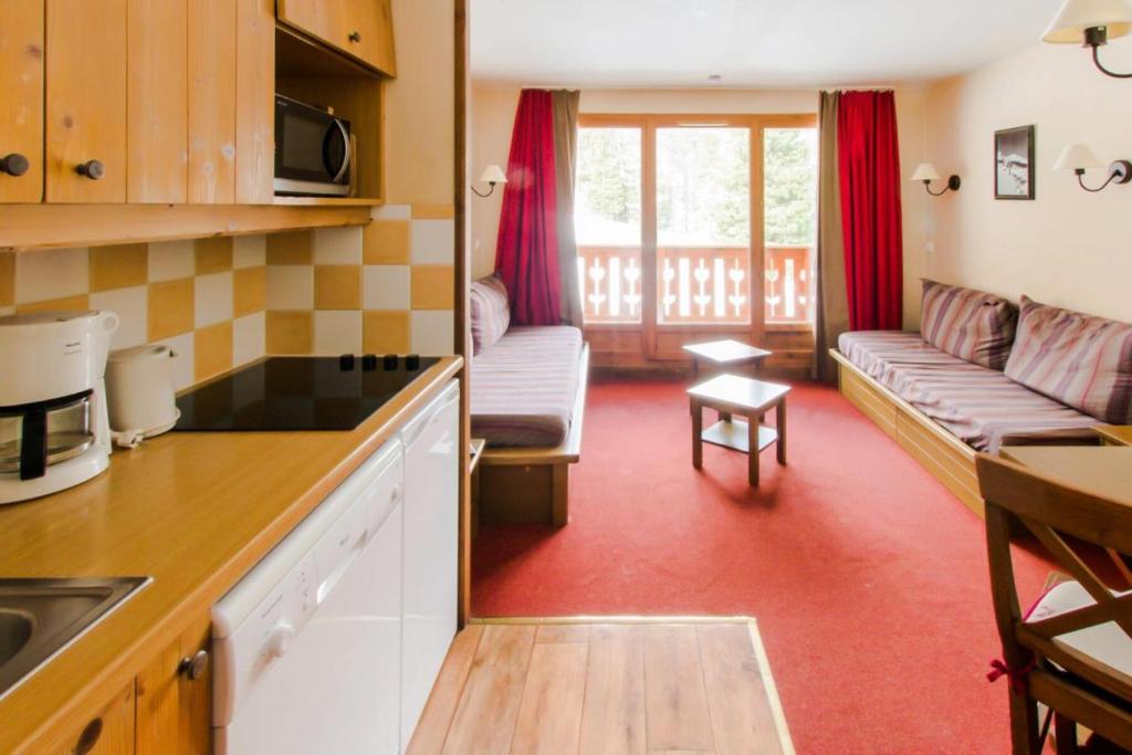 une cuisine et un salon avec un canapé dans l'établissement Résidence L'Albane - maeva Home - 2 Pièces 5 Personnes Sélection MAE-4506, à Vars