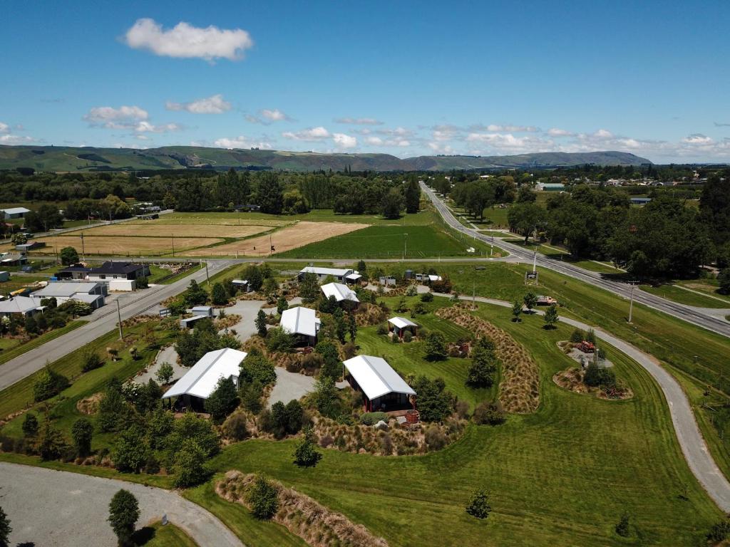 an aerial view of a farm with horses and buildings at Musterers Accommodation Fairlie in Fairlie