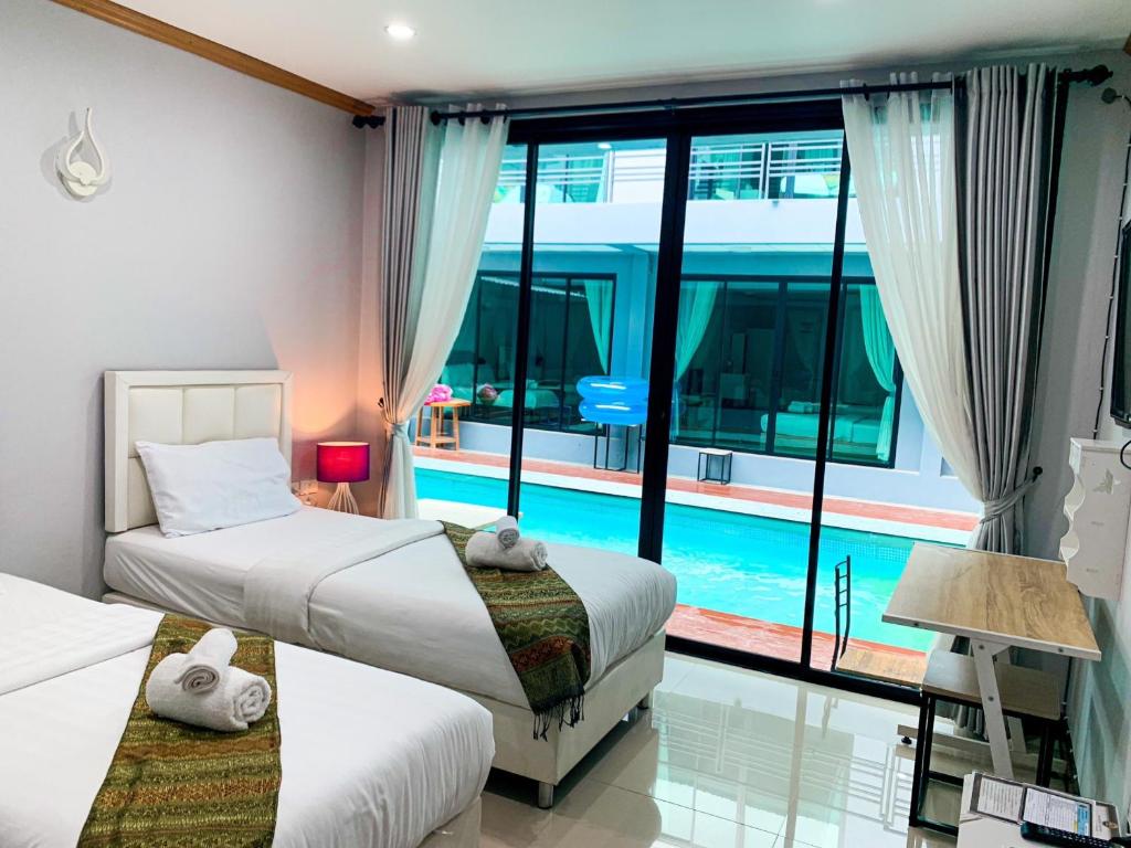 a bedroom with two beds and a swimming pool at Three Bridges Hotel in Nan