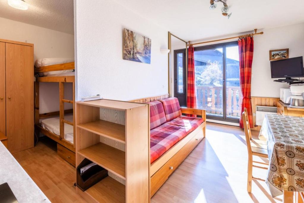 ein Wohnzimmer mit einem Sofa und einem Tisch in der Unterkunft Appartement 4 pers. au pied des pistes - Maeva Particuliers 69755 in L'Alpe-d'Huez