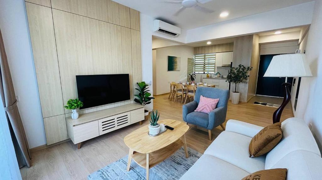 uma sala de estar com um sofá branco e uma televisão em Mutiara Melaka Beach Resort by Glex em Tangga Batu