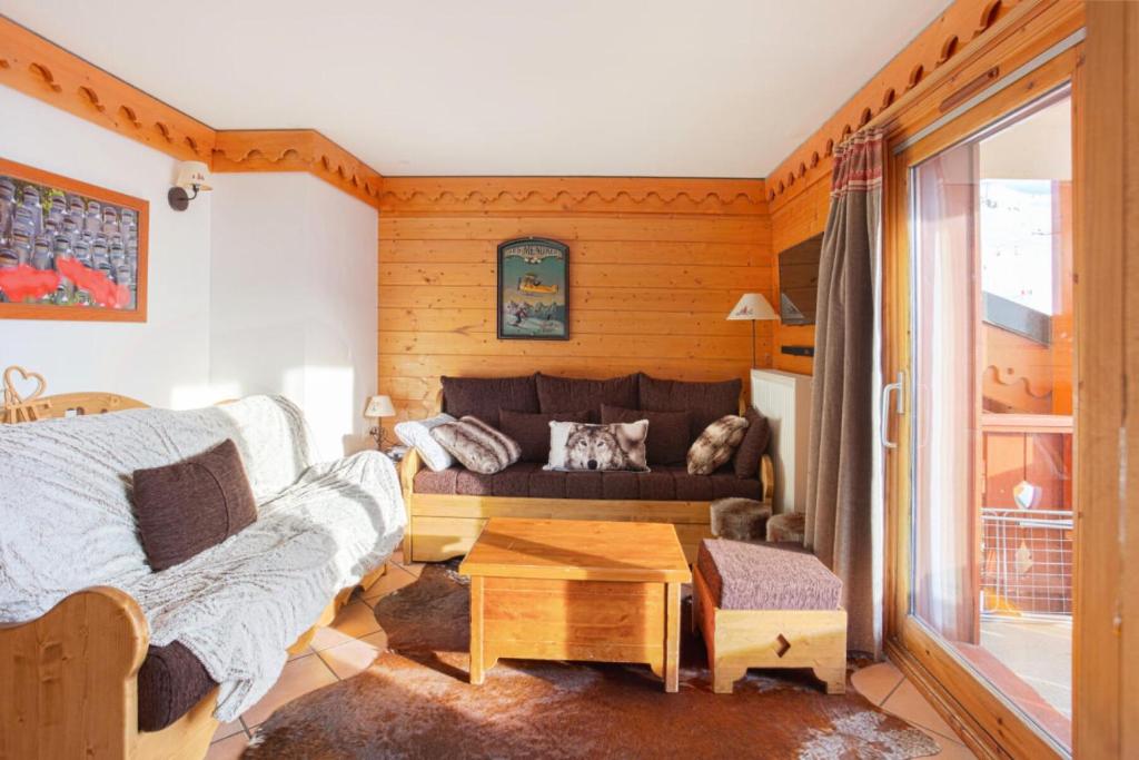 un salon avec un canapé et une table dans l'établissement Résidence Les Alpages de Reberty - maeva Home - 3 Pièces 8 Personnes Prestige MAE-4042, aux Menuires