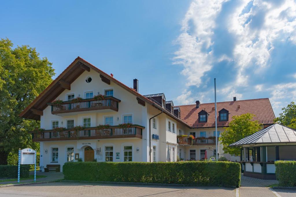 a white building with a brown roof at Servus Gelting in Geretsried