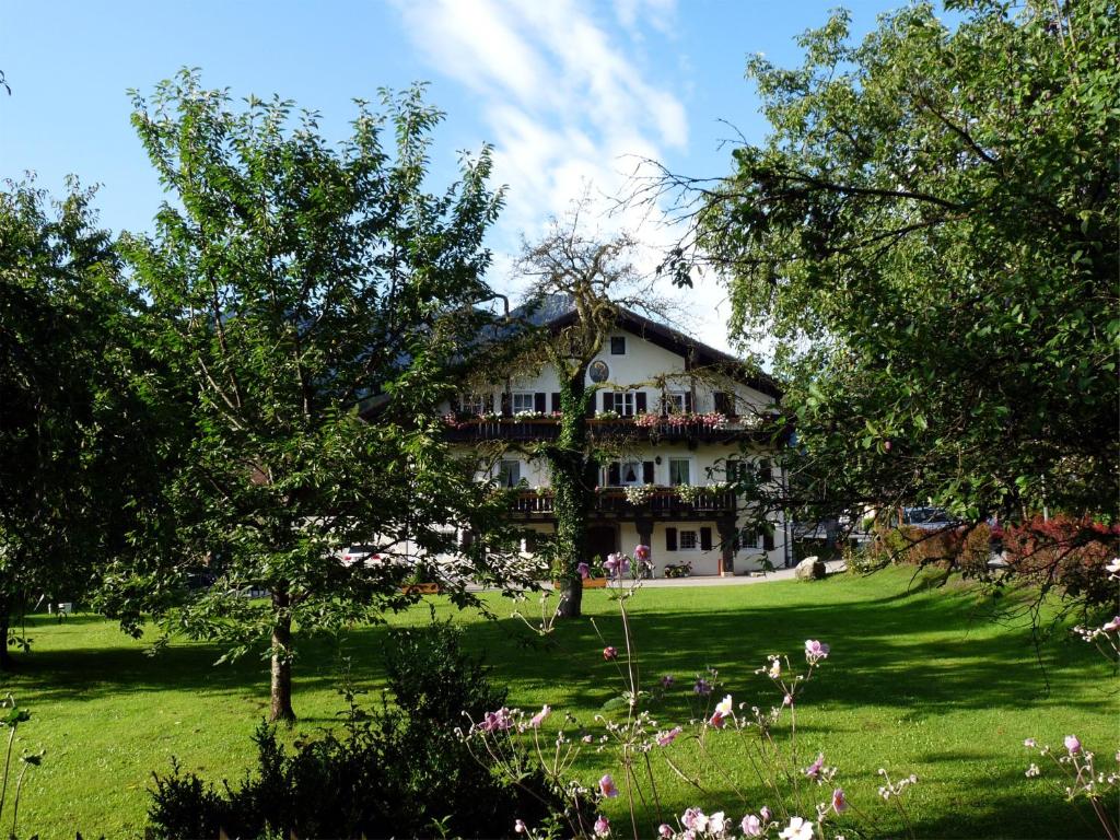 ein großes Gebäude auf einem grünen Feld mit Bäumen in der Unterkunft Pension Lex in Bad Reichenhall