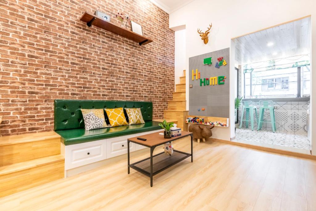 a living room with a green bench and a brick wall at Shanghai Hills&XING 1881 Homestay Near Line2 West Nanjing Rd in Shanghai