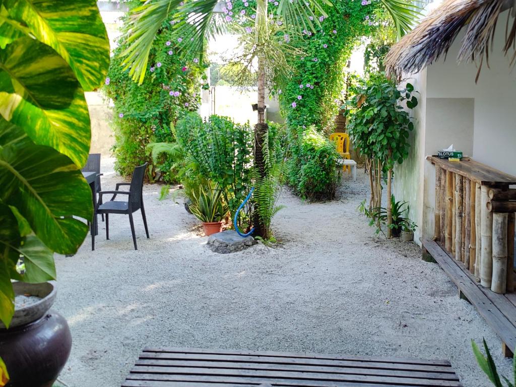 a garden with plants and a table and chairs at Oi Beach in Maamigili