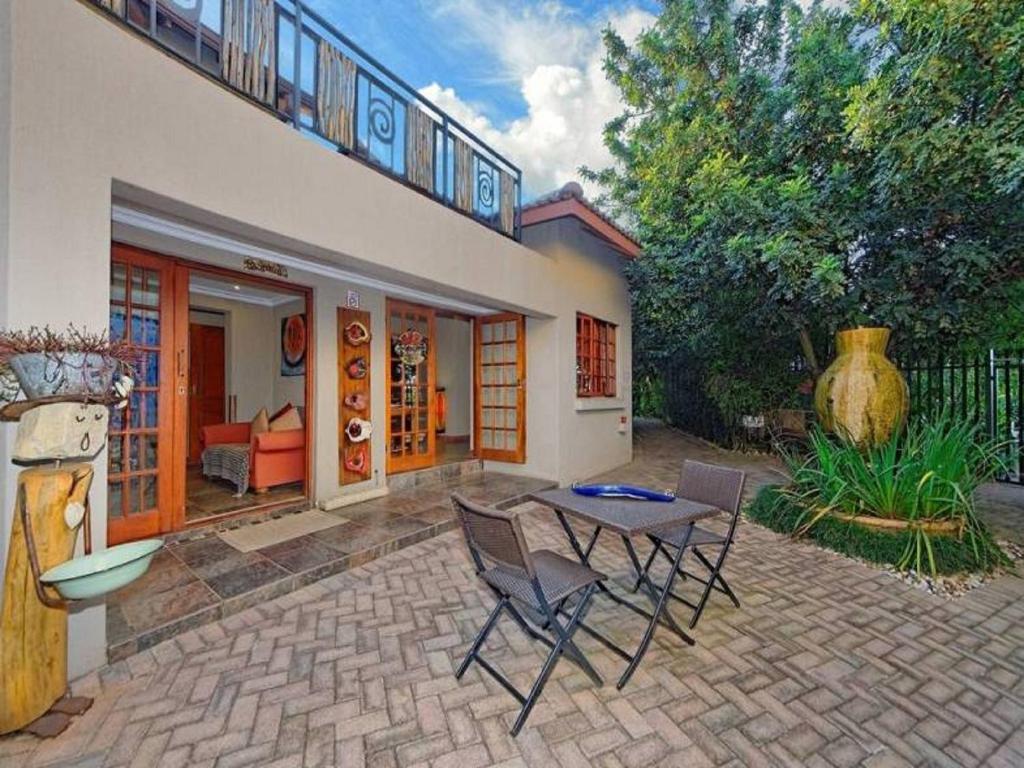 a house with a patio with a table and chairs at Amakoekoe Guest Lodge & Conference Venue in Johannesburg