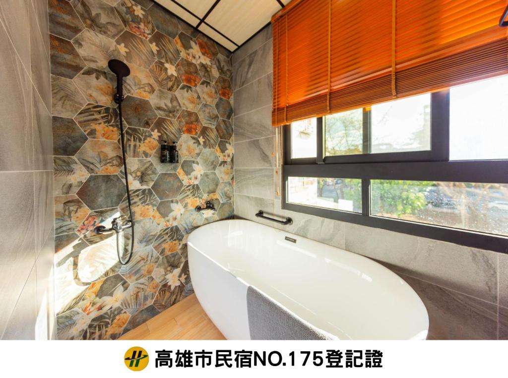 a bath tub in a bathroom with a stone wall at EZ STAY Yancheng in Kaohsiung