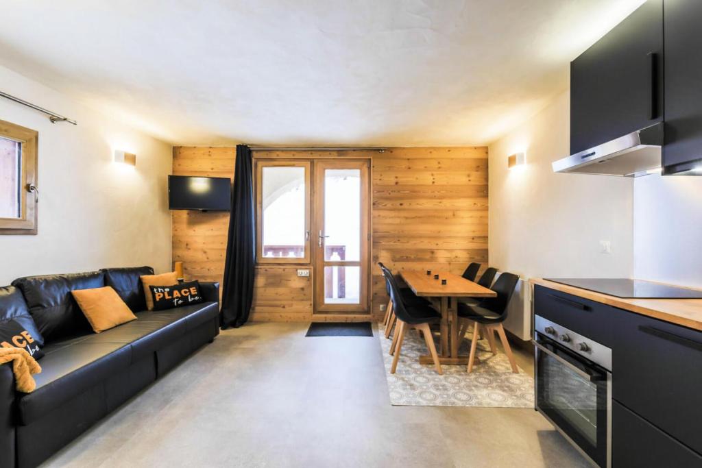 uma sala de estar com um sofá e uma mesa em Quartier Crève Cœur - maeva Home - Appartement 2 pièces 6 personnes skis a 76 em Valmorel