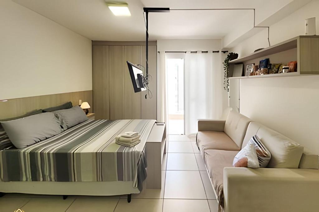 a bedroom with a bed and a couch at Studio Top Life: Garagem | Wifi | Ar-condicionado NA1002 in Juiz de Fora