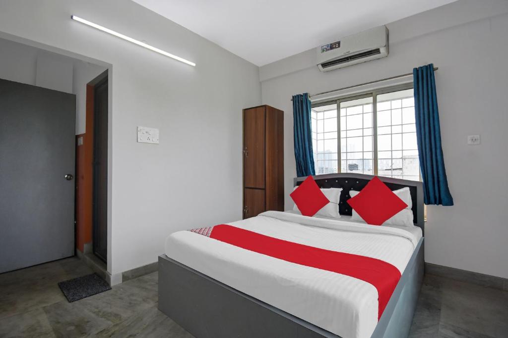 a bedroom with a large bed with red pillows at Super OYO Flagship J M T Upasana in Kolkata