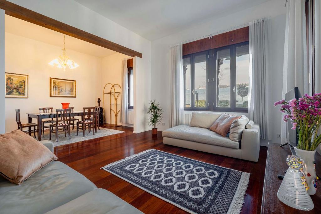 a living room with a couch and a table at Palazzo Boito Luxury Apartment on Lido with Venice view in Venice-Lido