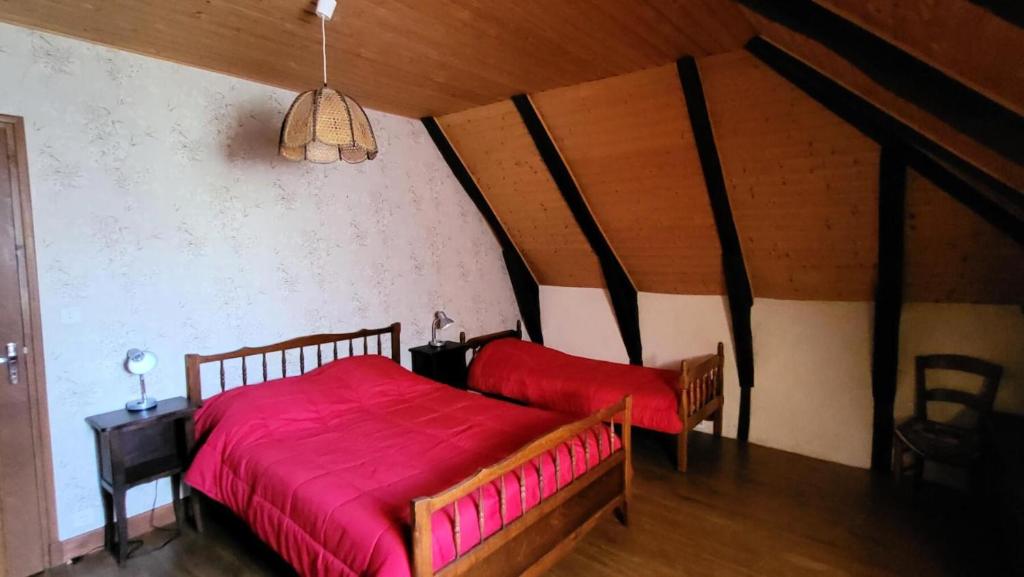 1 dormitorio con 1 cama con manta roja en Gîte de France à Latronche 2 épis - Gîte de France 4 personnes 634, 