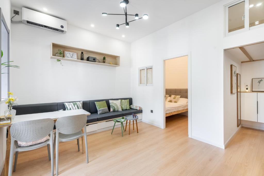 a living room with a table and chairs and a bed at Shanghai Hills&XING 1884 Family Homestay Near Line2 & Line12 West Nanjing Road in Shanghai
