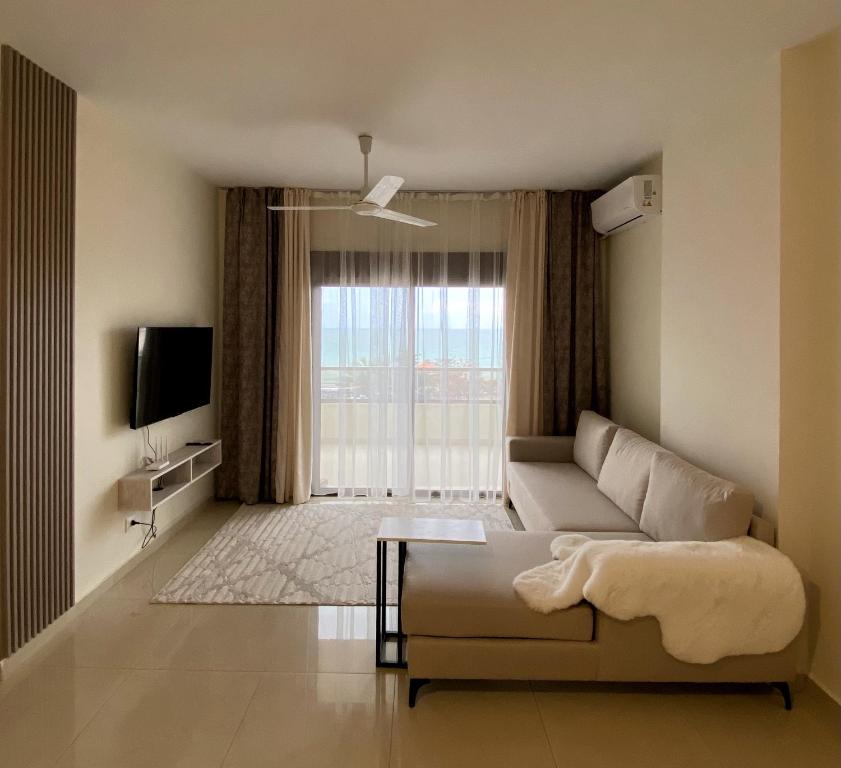 a living room with a couch and a large window at Nahr Ibrahim Suite 