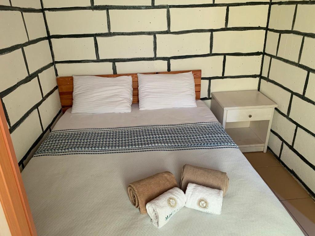 - une chambre avec un lit et des serviettes dans l'établissement Sunthalia Olympos Bungalow, à Kumluca