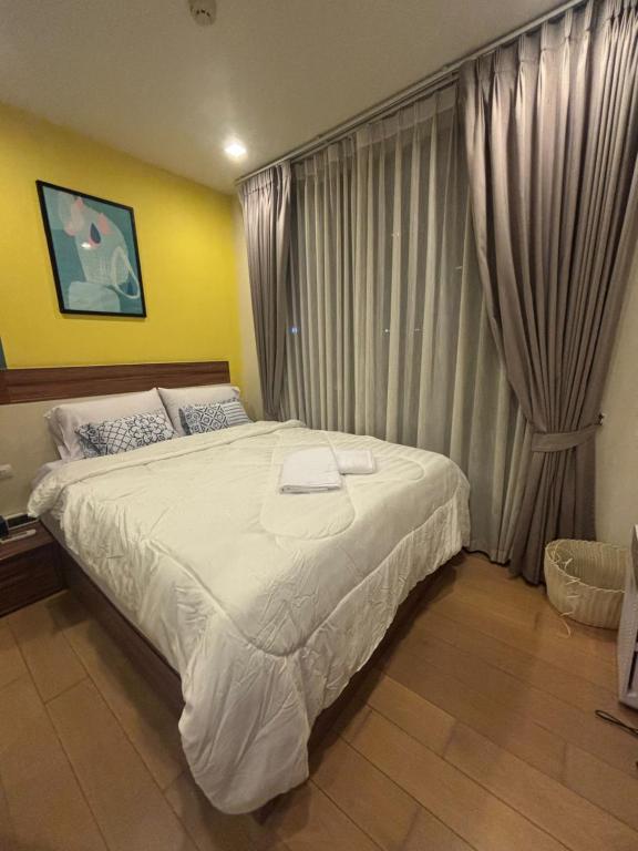 a bedroom with a large bed and a window at The Astra Bee friend in Chiang Mai