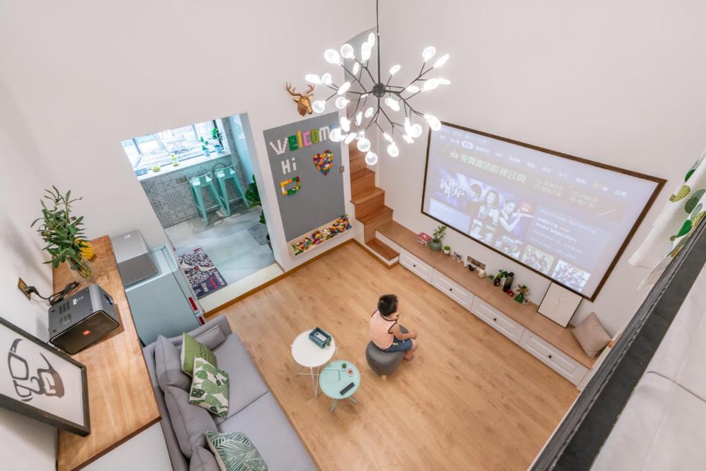 a boy sitting in a living room watching a tv at Shanghai Hills&XING 1882 Homestay Near Line2 & Line12 West Nanjing Rd in Shanghai