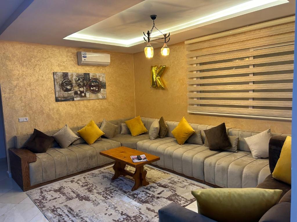 a living room with a large couch with yellow pillows at Apprt lux in Oujda