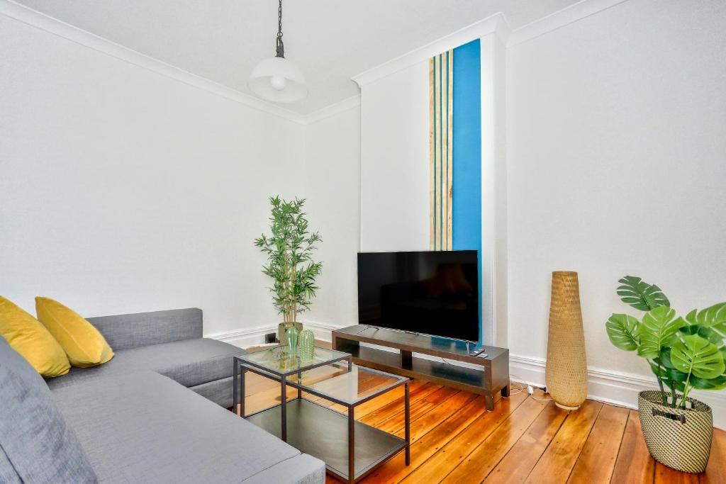 a living room with a couch and a tv at Family Friendly 3 Bedroom House Glebe 2 E-Bikes Included in Sydney