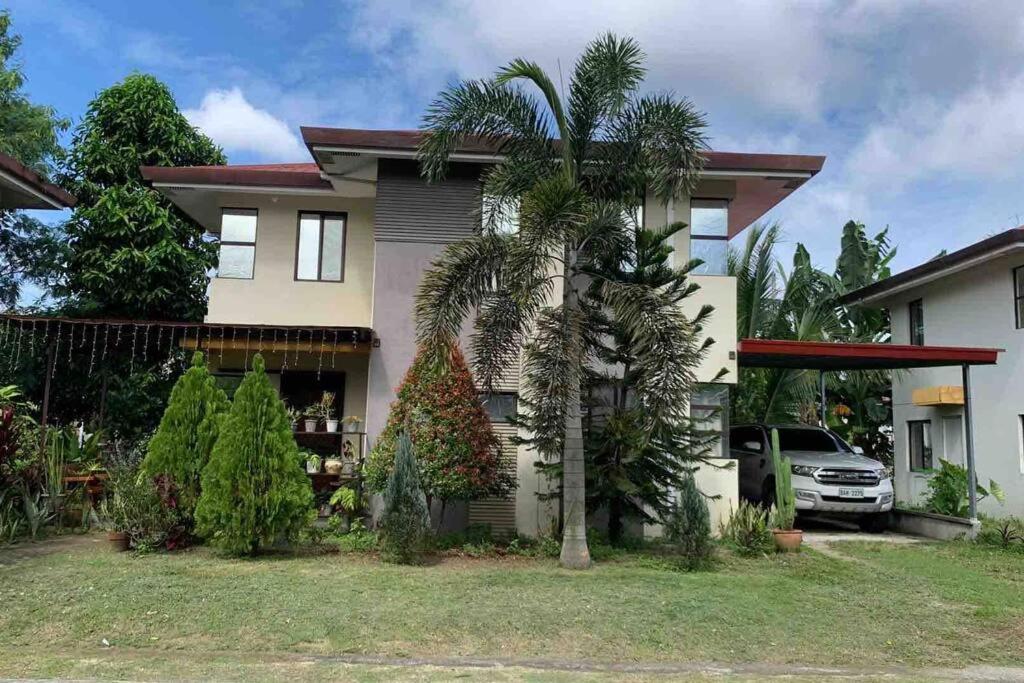 uma casa com uma palmeira em frente em Fully furnished spacious house in Nuvali em Calamba