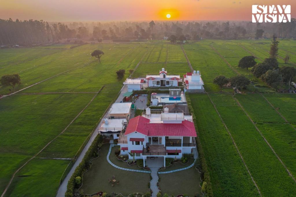 une vue aérienne d'une maison sur un champ dans l'établissement Hriday Bhoomi with Pool at Jim Corbett by StayVista, à Jhirna