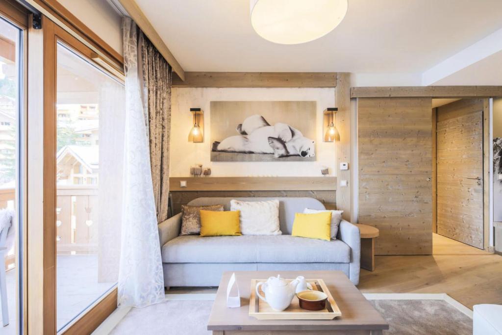 uma sala de estar com um sofá e uma cama em Résidence Premium L'Hévana - maeva Home - Appartement 3 pièces 6 personnes 53 em Les Allues