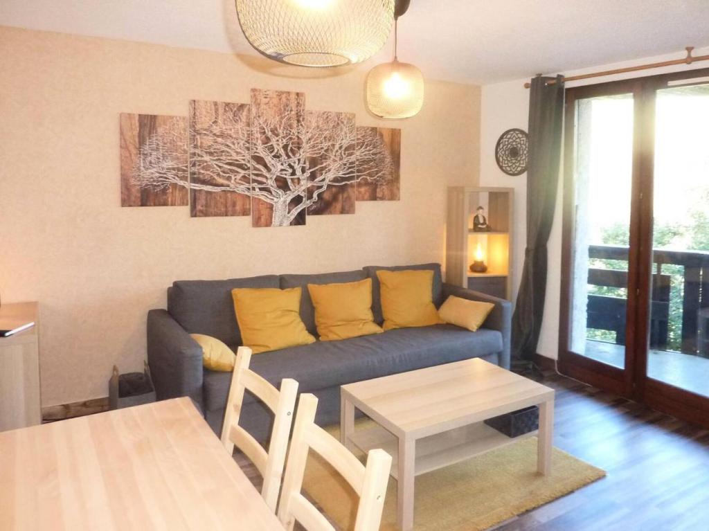 uma sala de estar com um sofá e uma mesa em Résidence AUPILLON - 2 Pièces pour 4 Personnes 044 em Les Orres