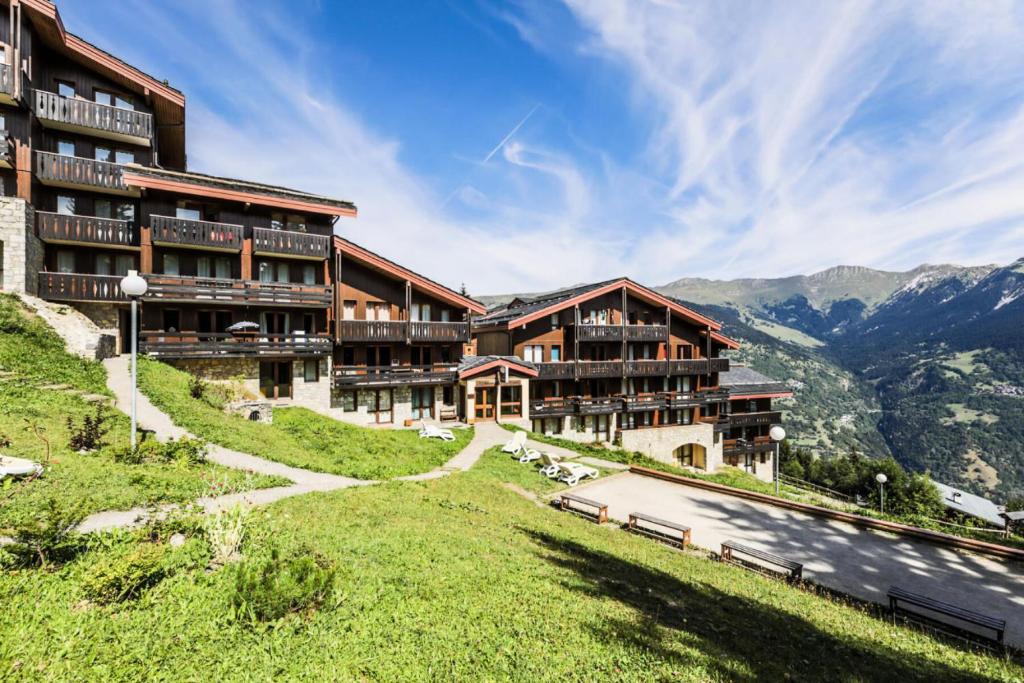 un hôtel sur une colline avec des montagnes en arrière-plan dans l'établissement Résidence Les Brigues - maeva Home - Appartement 2 Pièces 6 Personnes – Confort MAE-4702, à Courchevel