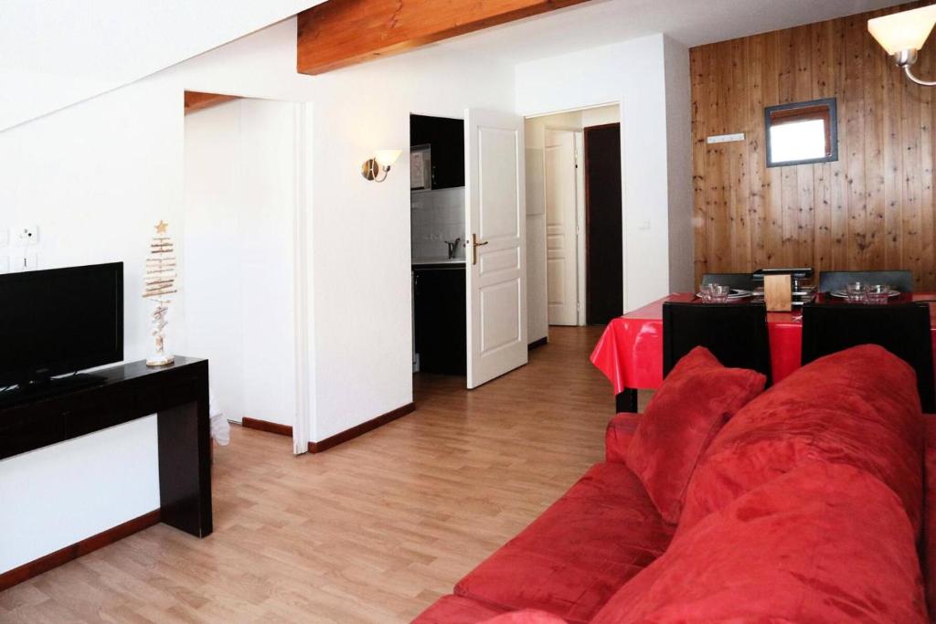 un salon avec un canapé rouge et une cuisine dans l'établissement Residence La Combe D Or - Appartement en résidence de standing MAE-6324, aux Orres