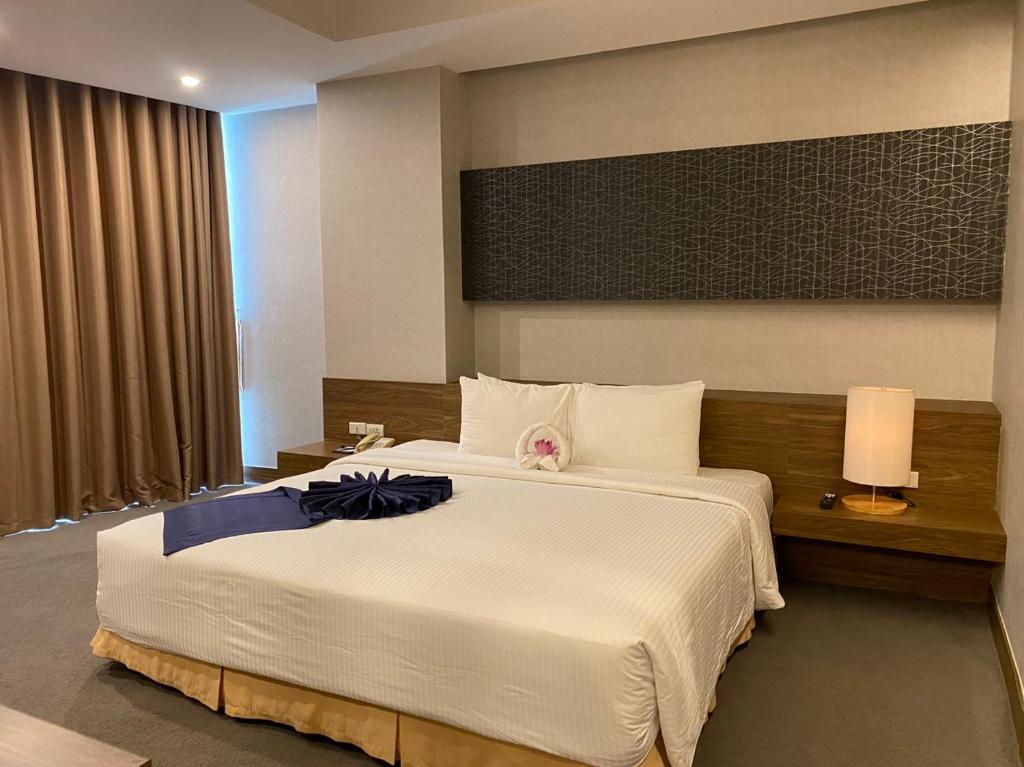 a bedroom with a large white bed with a flower on it at Muong Thanh Grand Xa La Hotel in Hanoi
