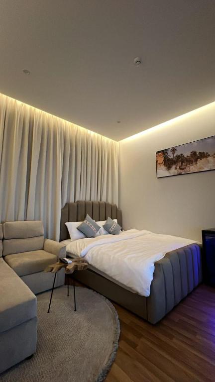 um quarto com uma cama grande e um sofá em استديو انيق بدخول ذاتي مستقل em Riade