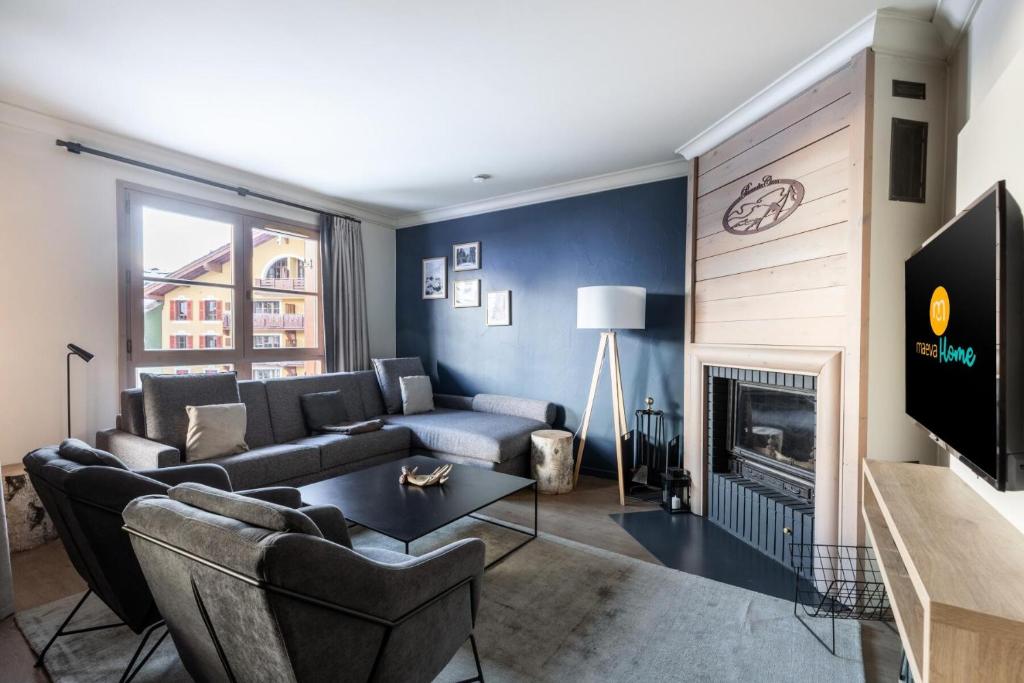 un salon avec un canapé et une cheminée dans l'établissement Résidence Les Arcs 1950 Le Village - maeva Home - 4 Pièces 10 Personnes Exclusive - Le Prince des Cîmes MAE-8360, à Bourg-Saint-Maurice