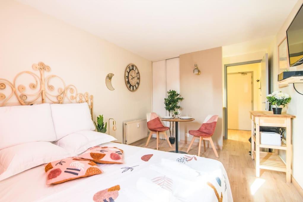 une chambre avec un lit, une table et des chaises dans l'établissement Le Lotus - Tram, à Strasbourg