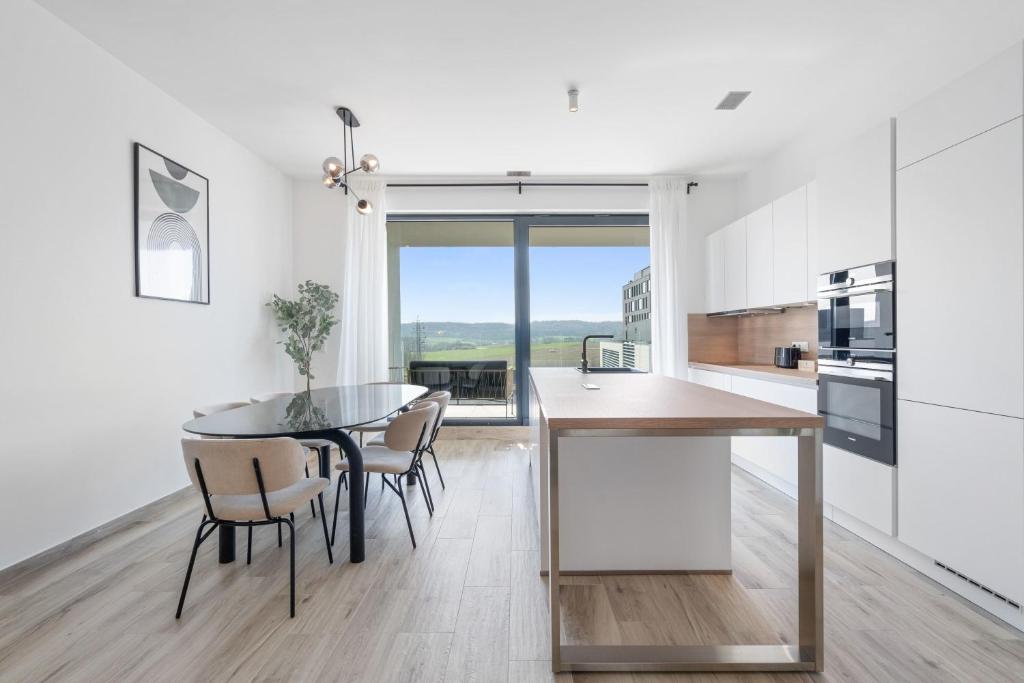 eine Küche und ein Esszimmer mit einem Tisch und Stühlen in der Unterkunft Chic 3BR Penthouse with Balcony and Smart TV in Esch-sur-Alzette