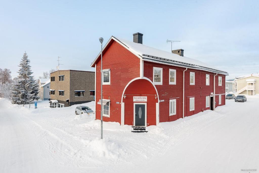 um edifício vermelho na neve com uma rua coberta de neve em Rum i Kalix em Kalix