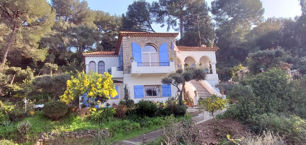 una casa con persianas azules y árboles en Magnifique "Gite de la Garoupe" au Cap d'Antibes à 300m des plages, en Antibes