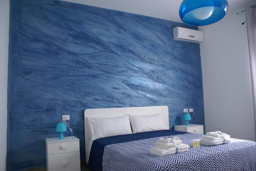 a blue bedroom with a bed and a blue wall at Alicata B&b La Dimora Del Vento in Licata