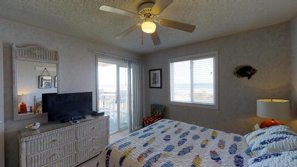 a bedroom with a bed and a ceiling fan at Beachmaster Unit 107 in Cherry Grove is an Oceanfront Condo in Myrtle Beach