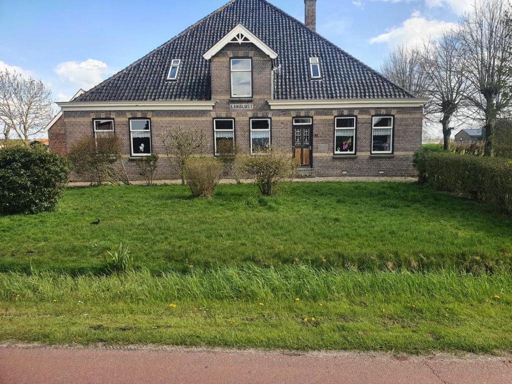 uma grande casa de tijolos com um telhado de gambrel em landlust.2 em Purmerend